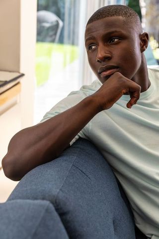 Thoughtful Man Relaxing and Gazing Out Contemporary Living Room
