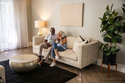 Senior couple relaxing on cozy sofa with modern interior elements