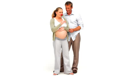 Expecting Couple Sharing Tender Moment With Red Rose