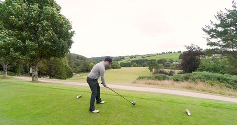 Golfer preparing to tee off on beautiful golf course with scenic landscape
