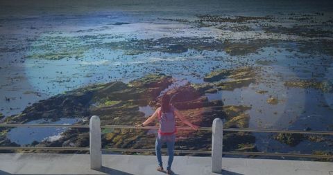 Woman Embracing Ocean View with Light Spots Creating Soft Glow