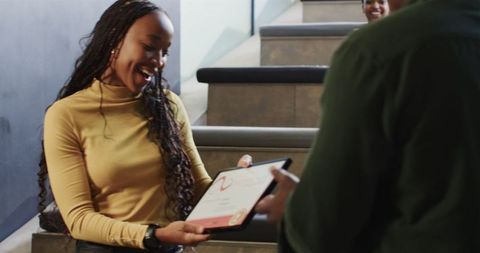Businesswoman celebrating award on office staircase