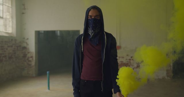 Mysterious Figure with Bandana Holding Yellow Smoke Bomb in Abandoned Building - Download Free Stock Images Pikwizard.com