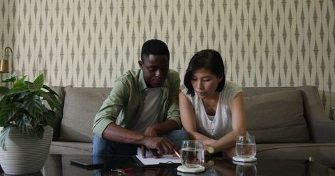 Diverse Colleagues Collaborating on Review in Cozy Living Space