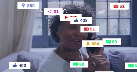 Senior woman talking on phone and receiving digital notifications at home