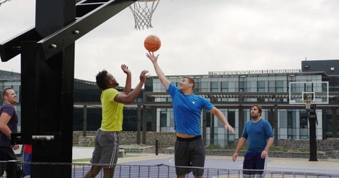 Men Enjoying Outdoor Basketball Game with Energetic Moves