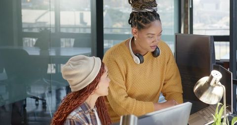 Diverse women collaborating at modern office workspace