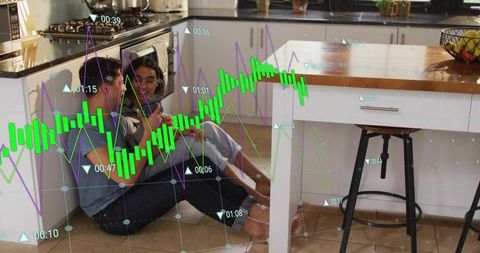 Couple sitting on kitchen floor sharing tablet while viewing financial analytics overlay
