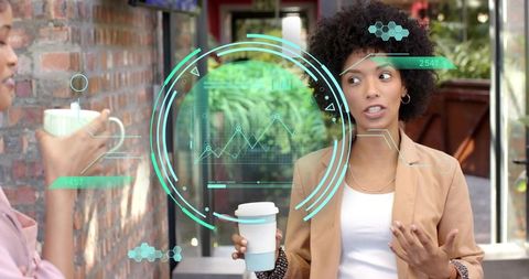 Young woman holding reusable cup talking with colleague while holographic data overlay displays char