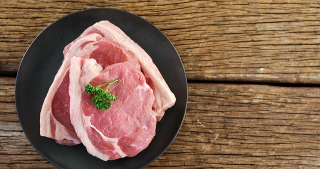 Raw Pork Chops on Black Plate with Rustic Wooden Background - Download Free Stock Images Pikwizard.com