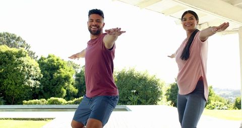 Friends enjoying outdoor yoga on sunny pergola deck
