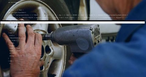 Mechanic tightening wheel using air impact wrench with programming code overlay