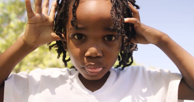 Playful African American Child Sticking Tongue Out in Sunlight - Download Free Stock Images Pikwizard.com