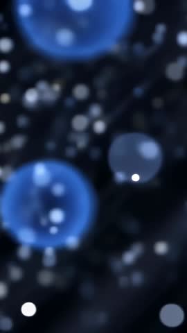 Vertical ambient abstract video with drifting white particles and rising blue bubbles