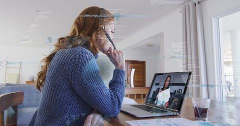 Woman working remotely with video call and data overlay