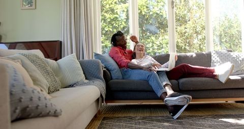 Diverse Couple Relaxing on Couch, Sharing Moments - Download Free Stock Images Pikwizard.com