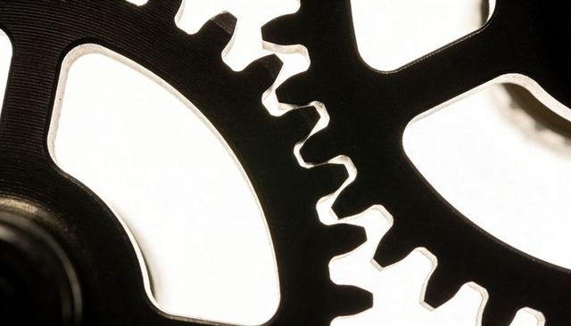 Meshing metal gears macro closeup backlit high-key mechanical precision industrial detail
