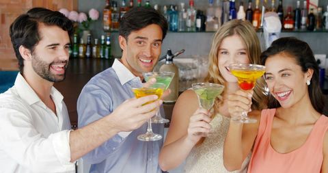 Cheerful Friends Toasting Colorful Cocktails at Bar Gathering - Download Free Stock Images Pikwizard.com