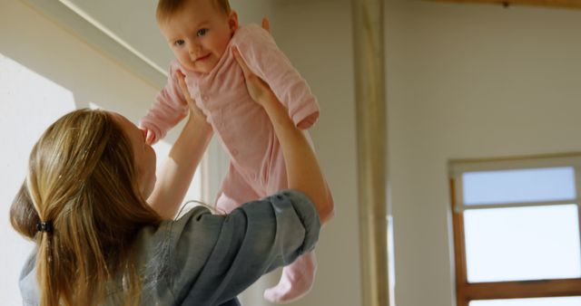 Mother Lifting Smiling Baby in Cozy Home Environment - Download Free Stock Images Pikwizard.com