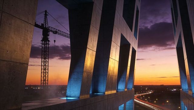 Sunset concrete facade framing with construction crane and highway light trails