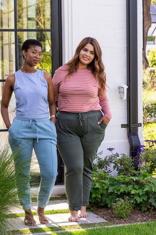 African american friends standing in garden wearing casual loungewear barefoot