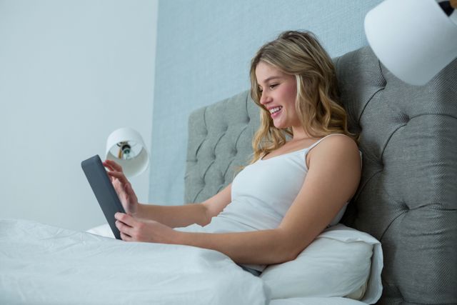 Woman using digital tablet on bed - Download Free Stock Photos Pikwizard.com