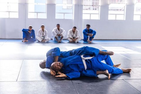 Martial Artists Engaged in Grappling Session at Training Studio