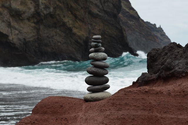 Balanced Stone Cairn on Rocky Beach with Waves Crashing in Background - Download Free Stock Photos Pikwizard.com