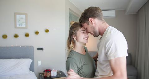 Cheerful Couple Dancing in Cozy Bedroom Embracing Love and Togetherness