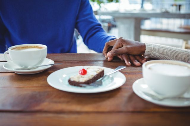 Couple Holding Hands Over Coffee and Cake in Cafe - Download Free Stock Photos Pikwizard.com