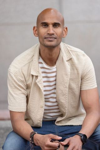 African american man looking confident in casual beige shirt and jeans, lifestyle portrait