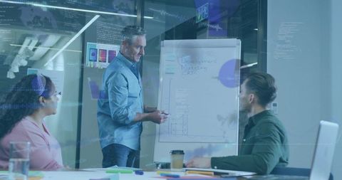 Presenting team leader explaining growth chart on flip chart in collaborative office meeting