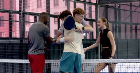 Friendly Padel Players Showing Sportsmanship at Glass Court