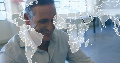 Smiling Professional with World Map Overlay in Modern Office