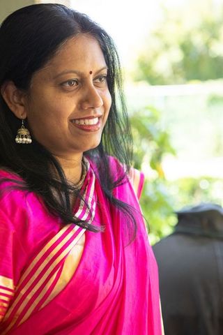 Senior Indian Woman in Vibrant Pink Sari Gazing at Foliage