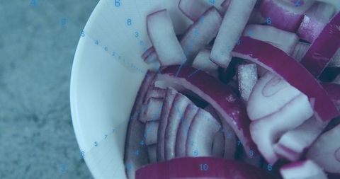 Displaying sliced red onion in white bowl with digital blue timer overlay macro texture
