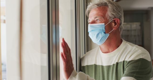 Senior Man Wearing Mask Looking Out Window Thoughtfully Indoors - Download Free Stock Images Pikwizard.com