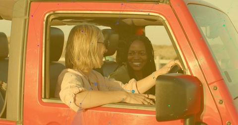 Smiling friends enjoying road trip in red jeep
