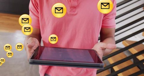 Man holding tablet receiving email notifications with floating yellow envelope icons in modern lobby