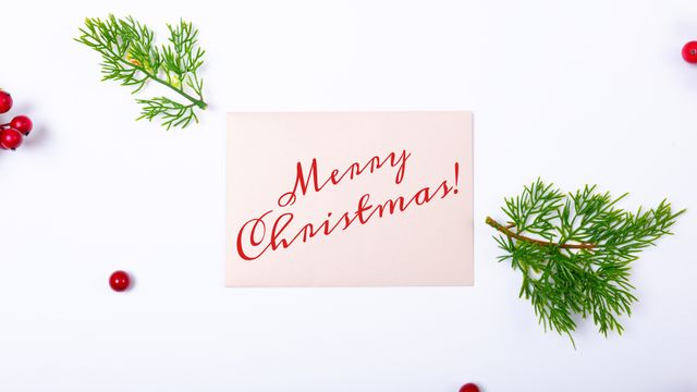Horizontal image of red merry christmas text, with red berries and tree sprigs on white background. Christmas, seasonal greetings, tradition and celebration concept digitally generated image.