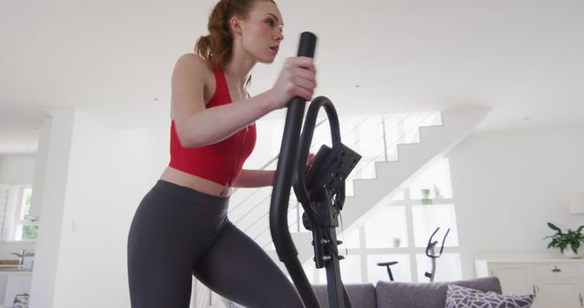 Young Woman Exercising on Elliptical Machine at Home - Download Free Stock Images Pikwizard.com