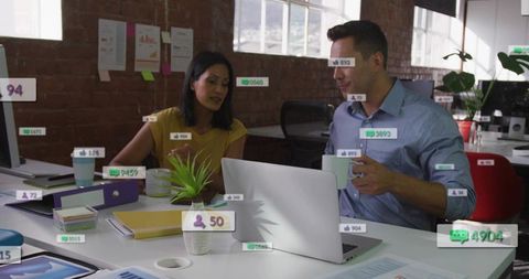 Coworkers collaborating over laptop in modern brick office with floating social metrics overlays