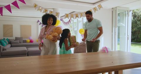 Family Celebrating Birthday with Gifts and Balloons at Home