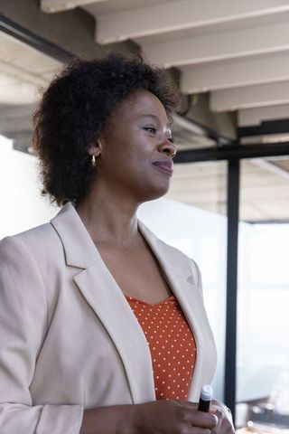 Confident businesswoman leading meeting in modern boardroom