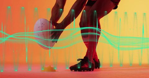 Soccer player positioning ball for kick in colorful studio