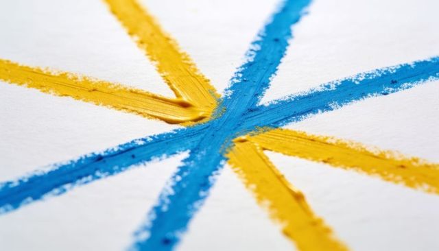 Converging blue and yellow paint strokes macro closeup showing impasto texture and granules