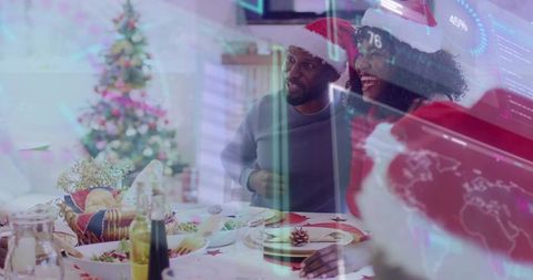 Family sharing joyful christmas dinner wearing santa hats with digital data overlay