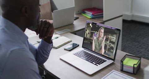 Businessman Engaged in Video Call Meeting with Colleague at Office Desk