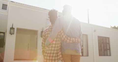African American Couple Embracing in Front of Their New Home