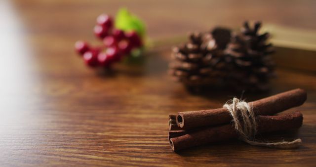 Image of christmas decorations with pine cones and cinnamon and red berries on wooden background - Download Free Stock Photos Pikwizard.com